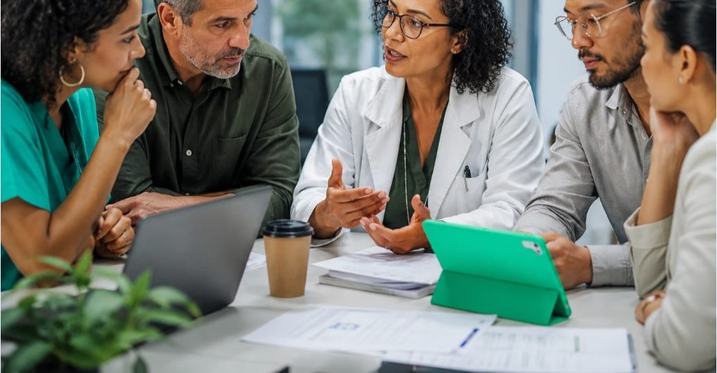 Equipe médica reunida discutindo em uma sala de reunião